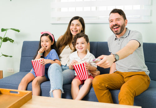 Cheerful parents enjoying a tv series with their kids